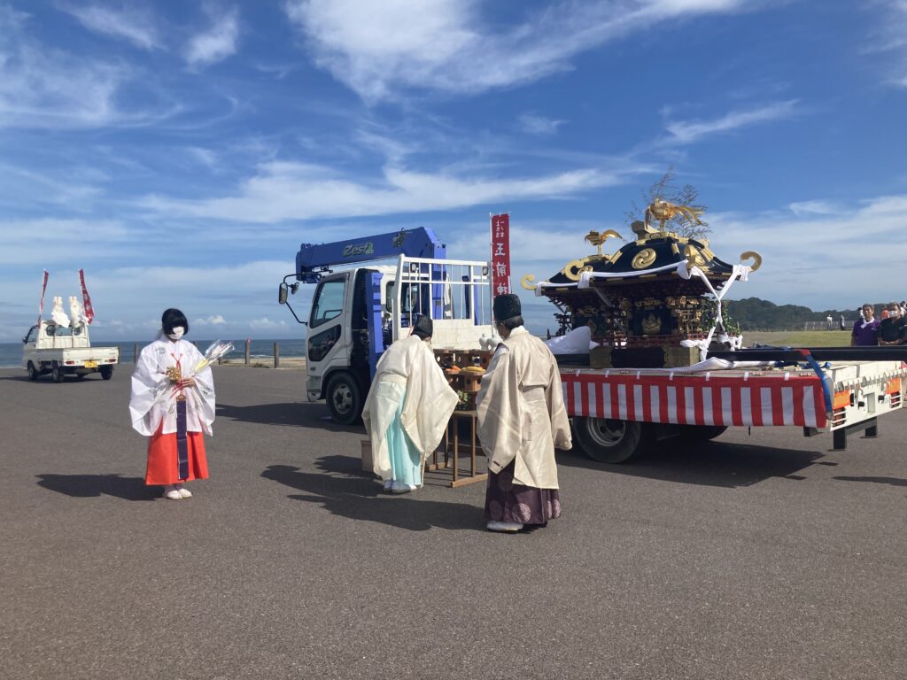 上総十二社祭りで釣ヶ埼海岸で神事を執り行う御神輿と宮司